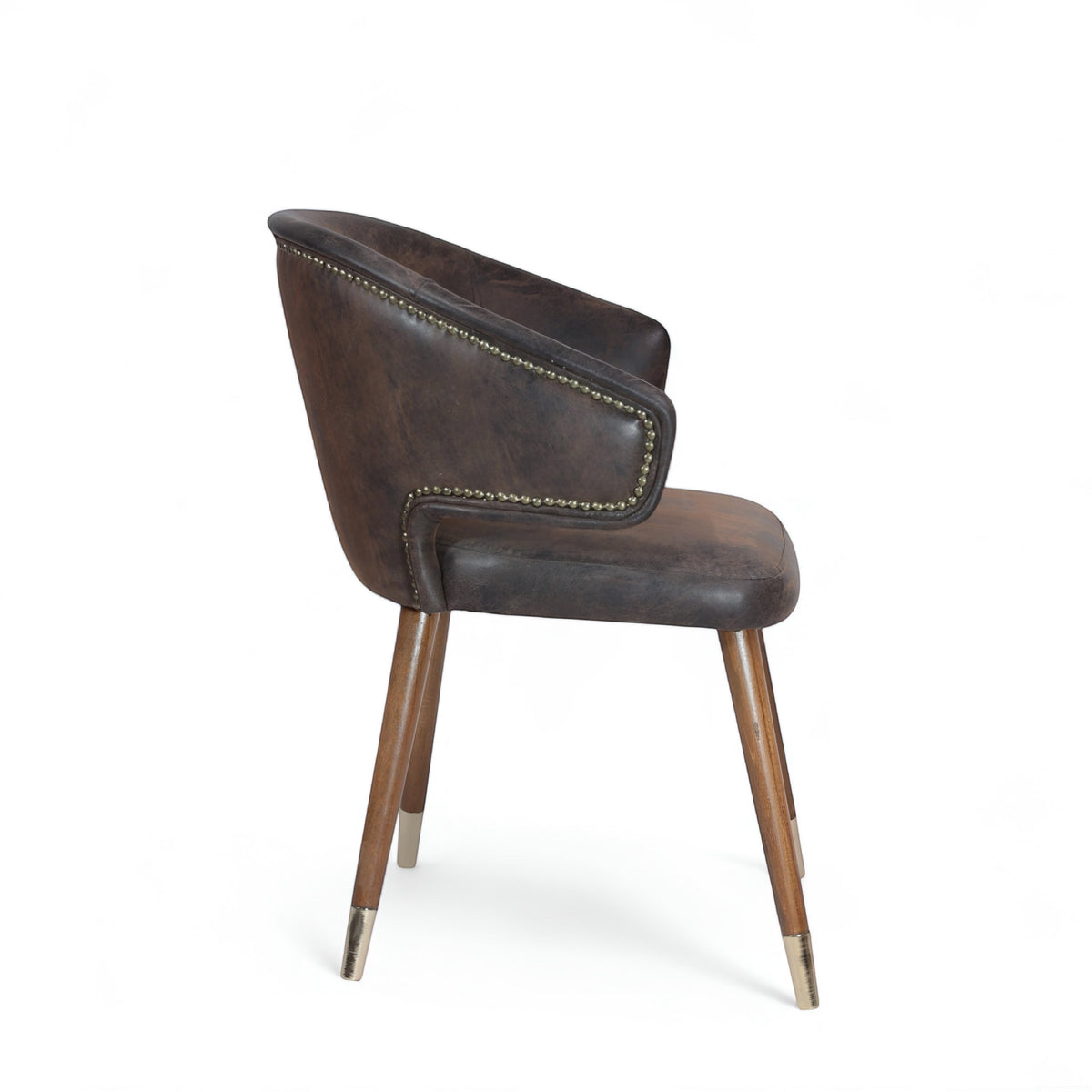 Side view of the Vaya Home Pelle accent chair with dark brown leather-look upholstery, curved back, nailhead trim, and tapered wood legs with metal caps.