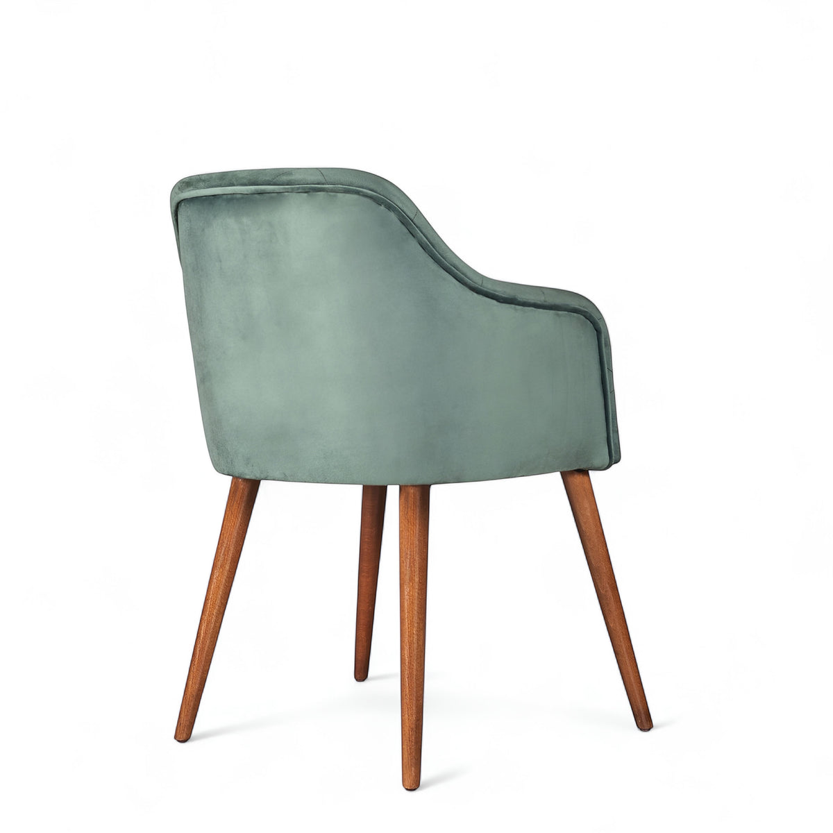 Rear angled view of the Vaya Home Pino dining chair featuring green velvet upholstery, a softly curved back, and tapered wood legs.