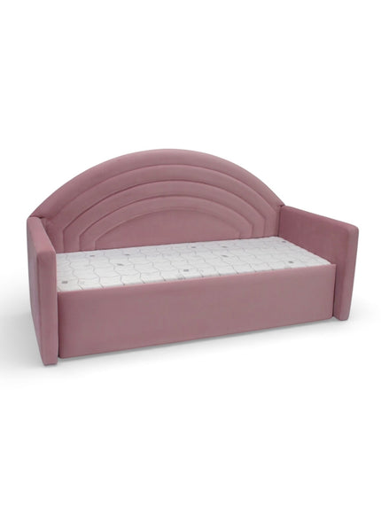 Angled front view of the Vaya Home Rainbow kids bed with pink upholstery, side arms, and an arched rainbow-style headboard.