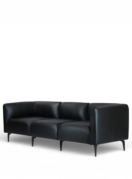 Angled view of the Vaya Home Regalo sofa with black leather upholstery, clean-lined arms, and slim metal legs.