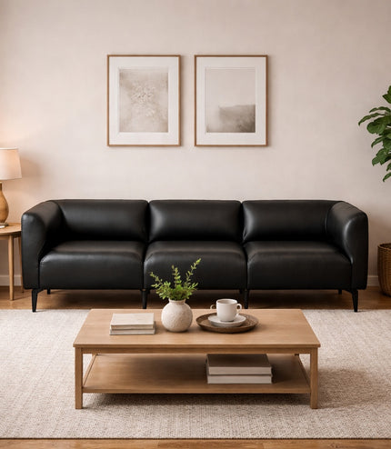 Vaya Home Regalo sofa in black leather, styled in a modern living room.