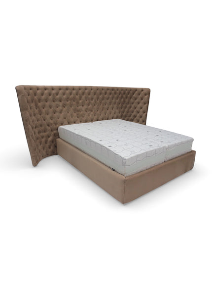 Side angled view of the Vaya Home Regent bed with taupe upholstery and a tufted wingback headboard.
