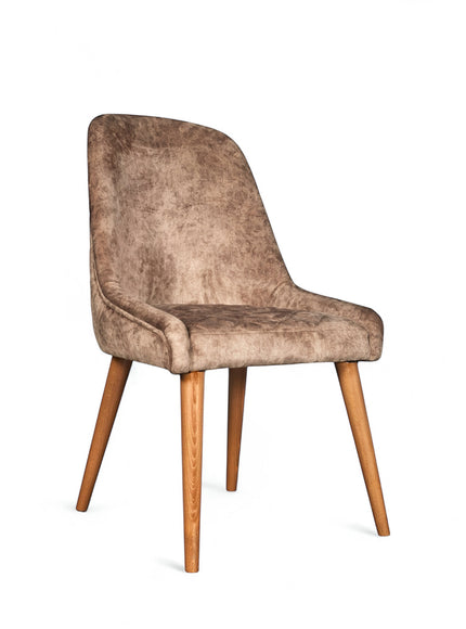 Front angled view of the Vaya Home Reverie dining chair in beige leather velvet upholstery with a cushioned seat and tapered wood legs.