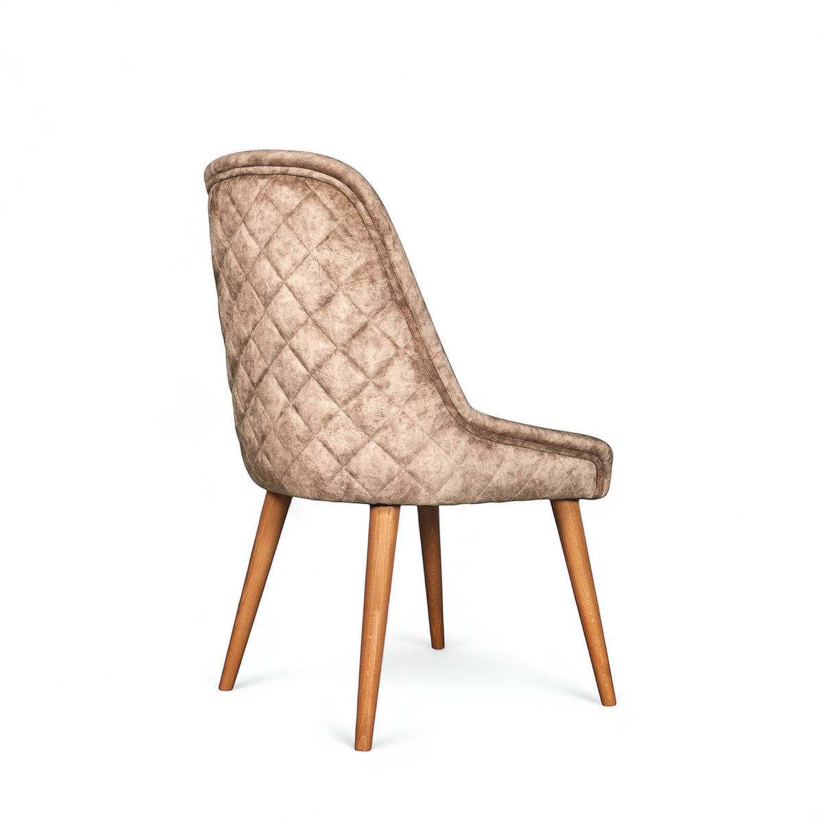 Rear angled view of the Vaya Home Reverie dining chair featuring beige leather velvet upholstery, diamond-quilted back detail, and tapered wood legs.