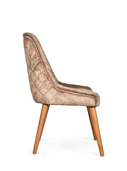 Side view of the Vaya Home Reverie dining chair in beige leather velvet upholstery with a slim profile and tapered wood legs.