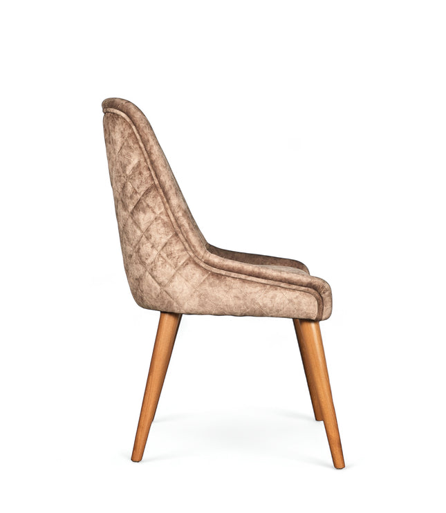 Side view of the Vaya Home Reverie dining chair in beige leather velvet upholstery with a slim profile and tapered wood legs.