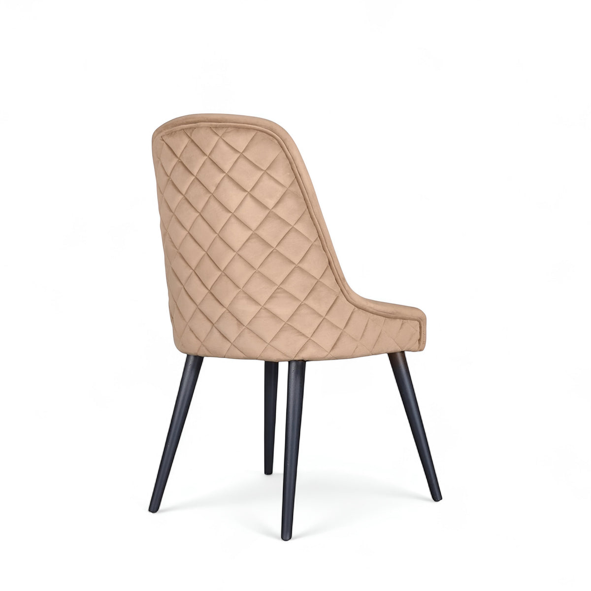 Rear angled view of the Vaya Home Reverie dining chair featuring beige upholstery, diamond-quilted back detail, and black tapered legs.
