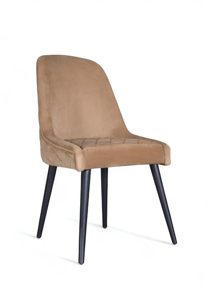 Side view of the Vaya Home Reverie dining chair with beige upholstery, slim profile, and black tapered legs.