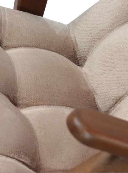 Close-up of the Vaya Home Riposo accent chair showing beige tufted upholstery and wood arm detail.