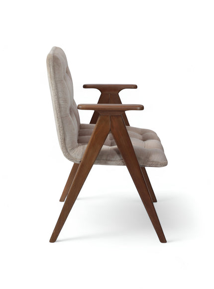 Side view of the Vaya Home Riposo accent chair featuring beige tufted upholstery, sculpted wood arms, and angled wood legs.