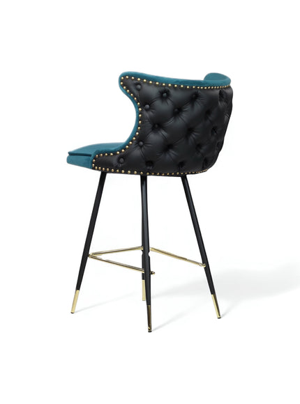 Rear angled view of the Vaya Home Roket bar stool with black tufted upholstery, blue trim, nailhead detailing, and black metal legs with gold accents.