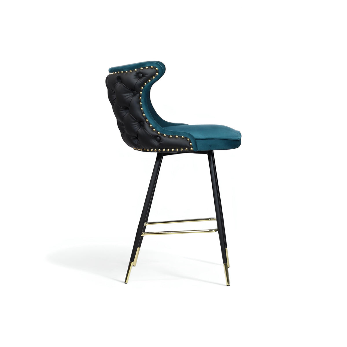 Side view of the Vaya Home Roket bar stool with blue seat upholstery, black button-tufted back, nailhead trim, and black metal legs with gold accents.