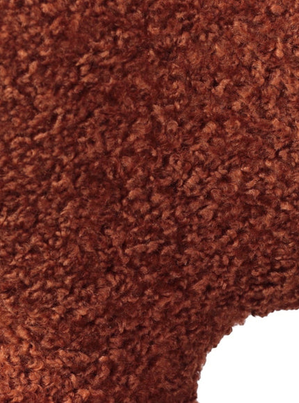 Close-up of the Vaya Home Rolf accent chair showing orange boucle upholstery texture.