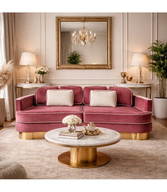 Vaya Home Rose curved sofa in pink velvet with a gold base, styled in an elegant living room.