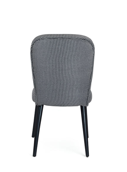 Back view of the Vaya Home Scacchi dining chair featuring black and white houndstooth upholstery and black tapered legs.