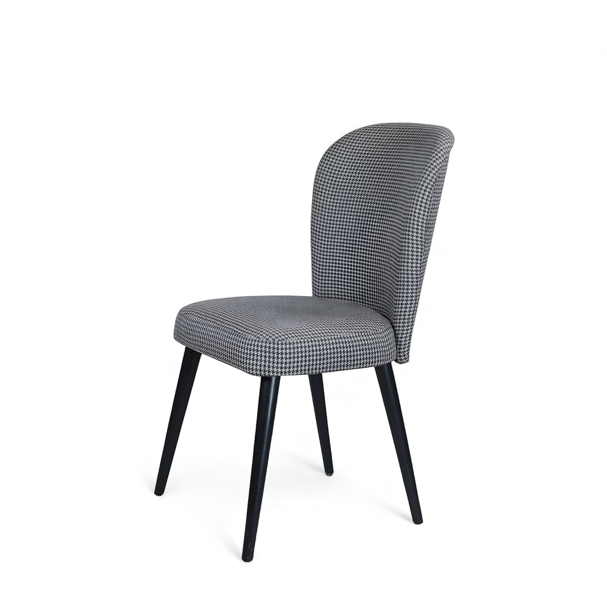Front angled view of the Vaya Home Scacchi dining chair featuring black and white houndstooth upholstery and black tapered legs.