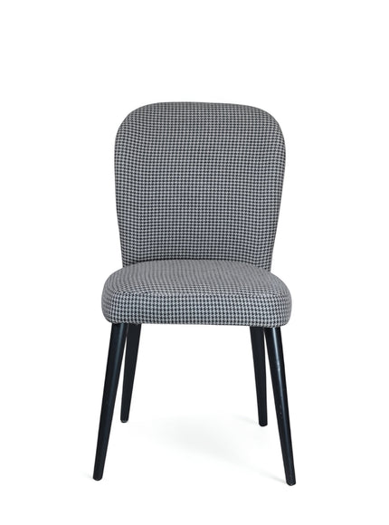 Front view of the Vaya Home Scacchi dining chair with black and white houndstooth upholstery and black tapered legs.