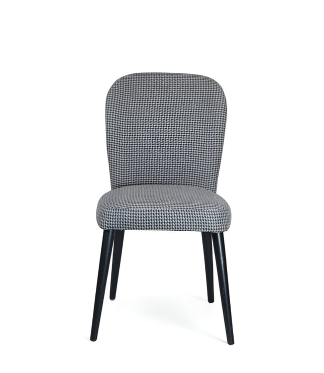 Front view of the Vaya Home Scacchi dining chair with black and white houndstooth upholstery and black tapered legs.