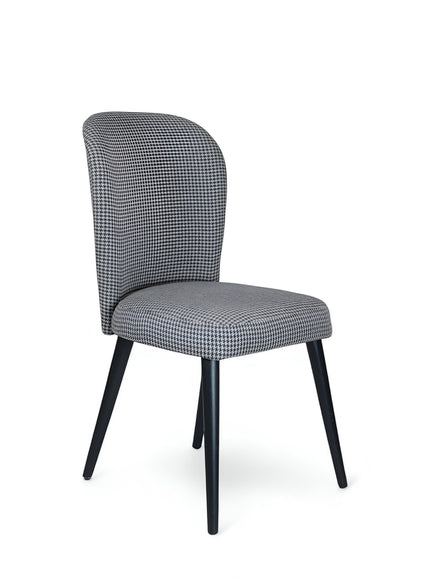 Product view of the Vaya Home Scacchi dining chair in black and white houndstooth upholstery with black tapered legs.