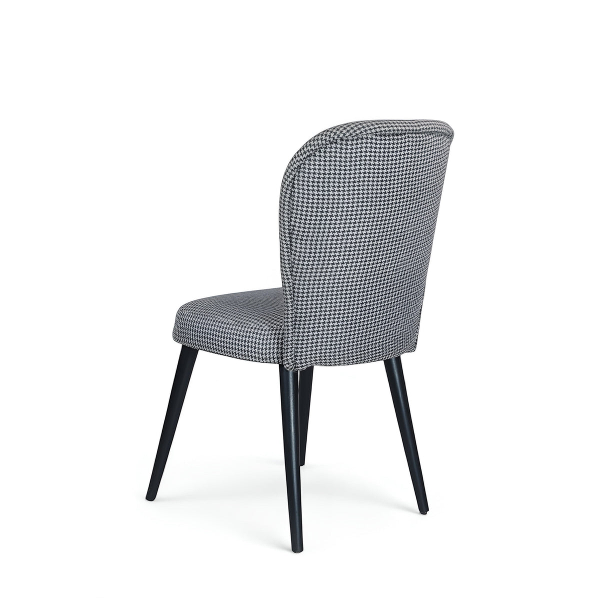 Rear angled view of the Vaya Home Scacchi dining chair featuring houndstooth upholstery and black tapered legs.