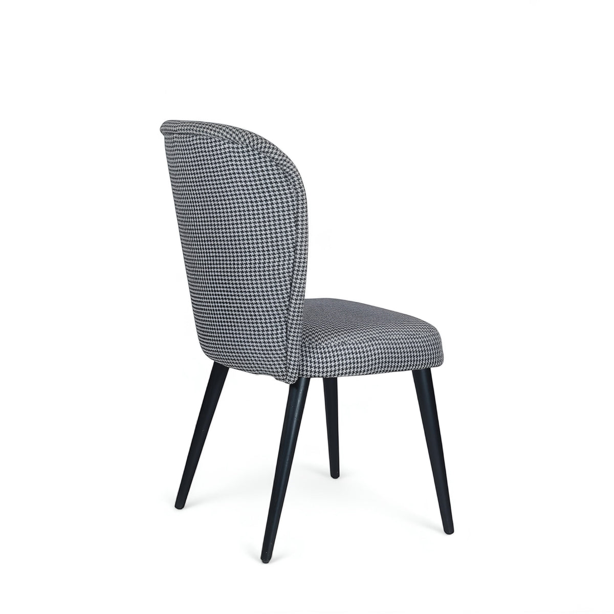 Side view of the Vaya Home Scacchi dining chair with black and white houndstooth upholstery and black tapered legs.