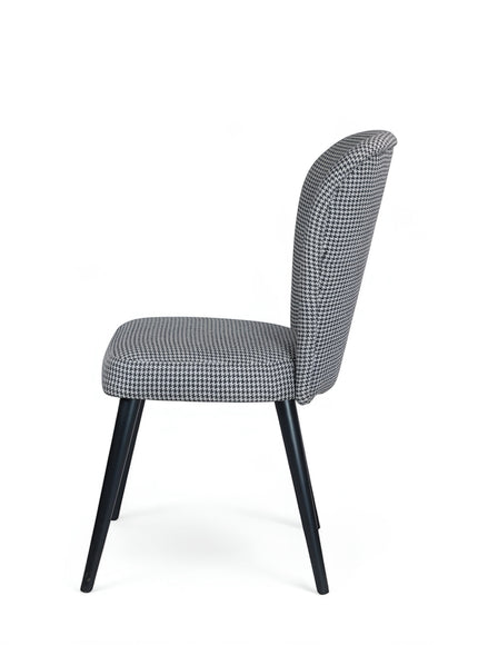 Opposite side view of the Vaya Home Scacchi dining chair with houndstooth upholstery and black tapered legs.
