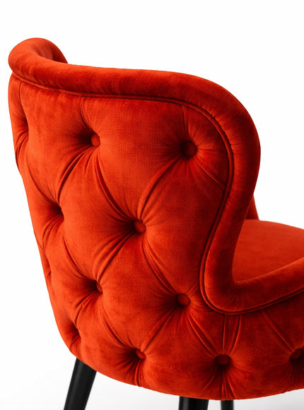 Vaya Home Sienna orange velvet accent chair with button tufting and curved backrest.