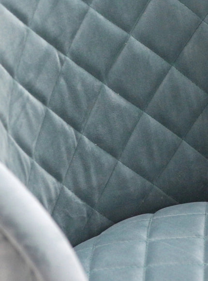 Close-up of the Vaya Home Silver dining chair showing blue quilted upholstery detail.