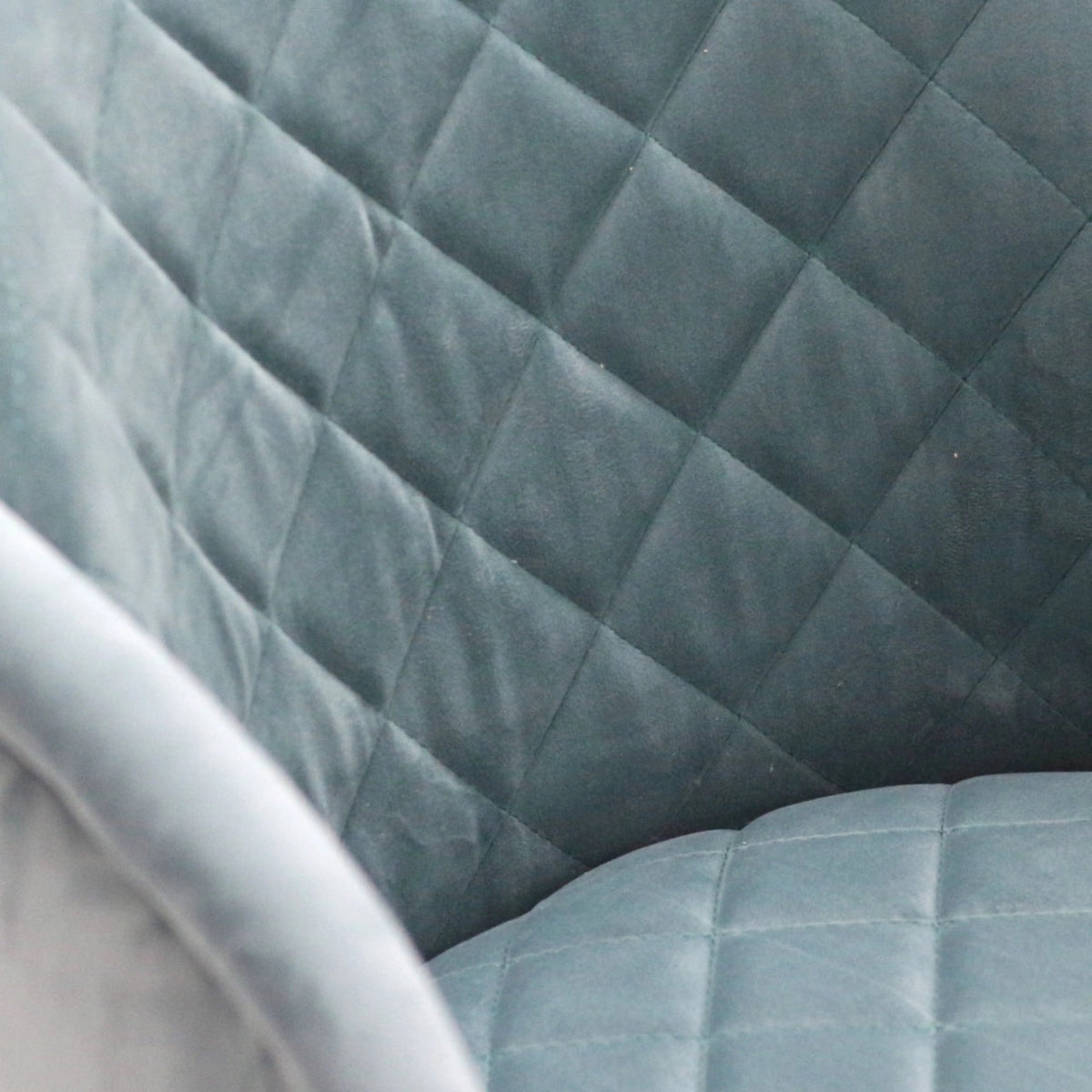 Close-up of the Vaya Home Silver dining chair showing blue quilted upholstery detail.