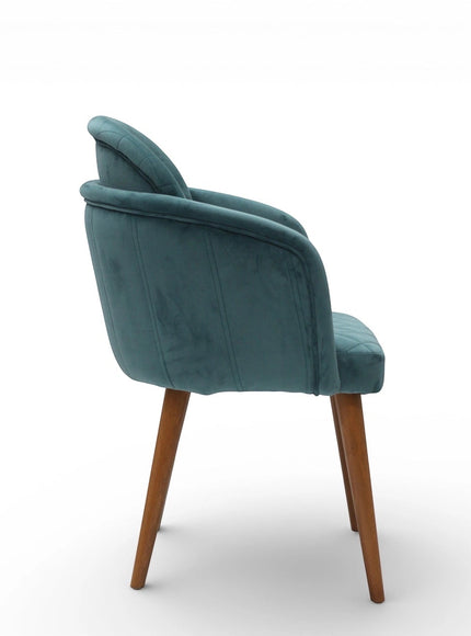 Side rear view of the Vaya Home Silver dining chair featuring blue upholstery, rounded back, and tapered wood legs.