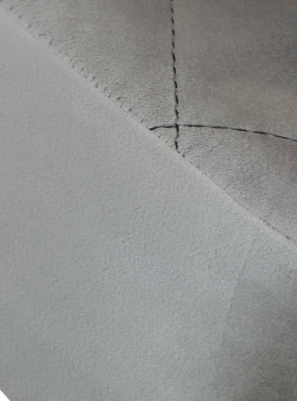 Close-up of the Vaya Home Silver dining chair showing gray upholstery and stitched seam detail.