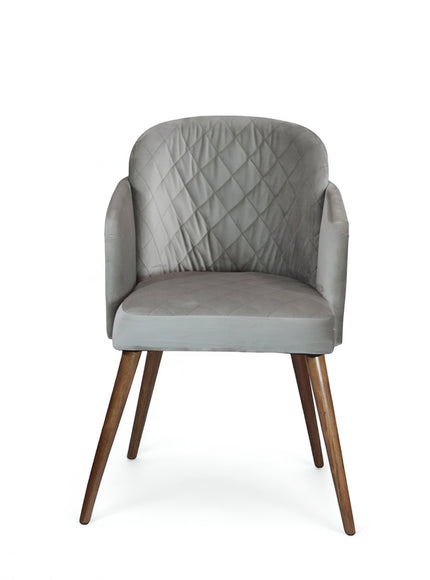 Front view of the Vaya Home Silver dining chair with gray upholstery, diamond-quilted backrest, curved arms, and tapered wood legs.