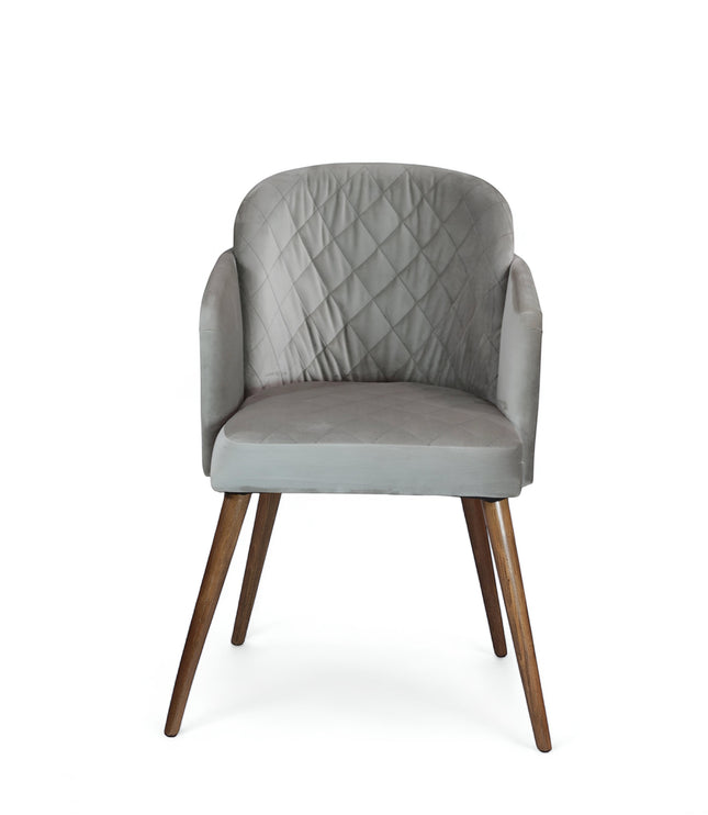 Front view of the Vaya Home Silver dining chair with gray upholstery, diamond-quilted backrest, curved arms, and tapered wood legs.