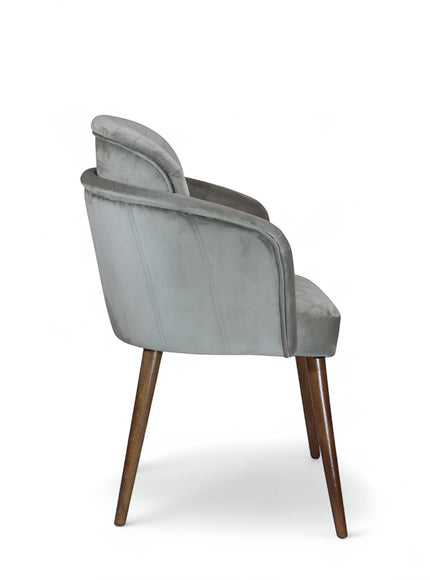 Side rear view of the Vaya Home Silver dining chair with gray upholstery, curved back, and tapered wood legs.