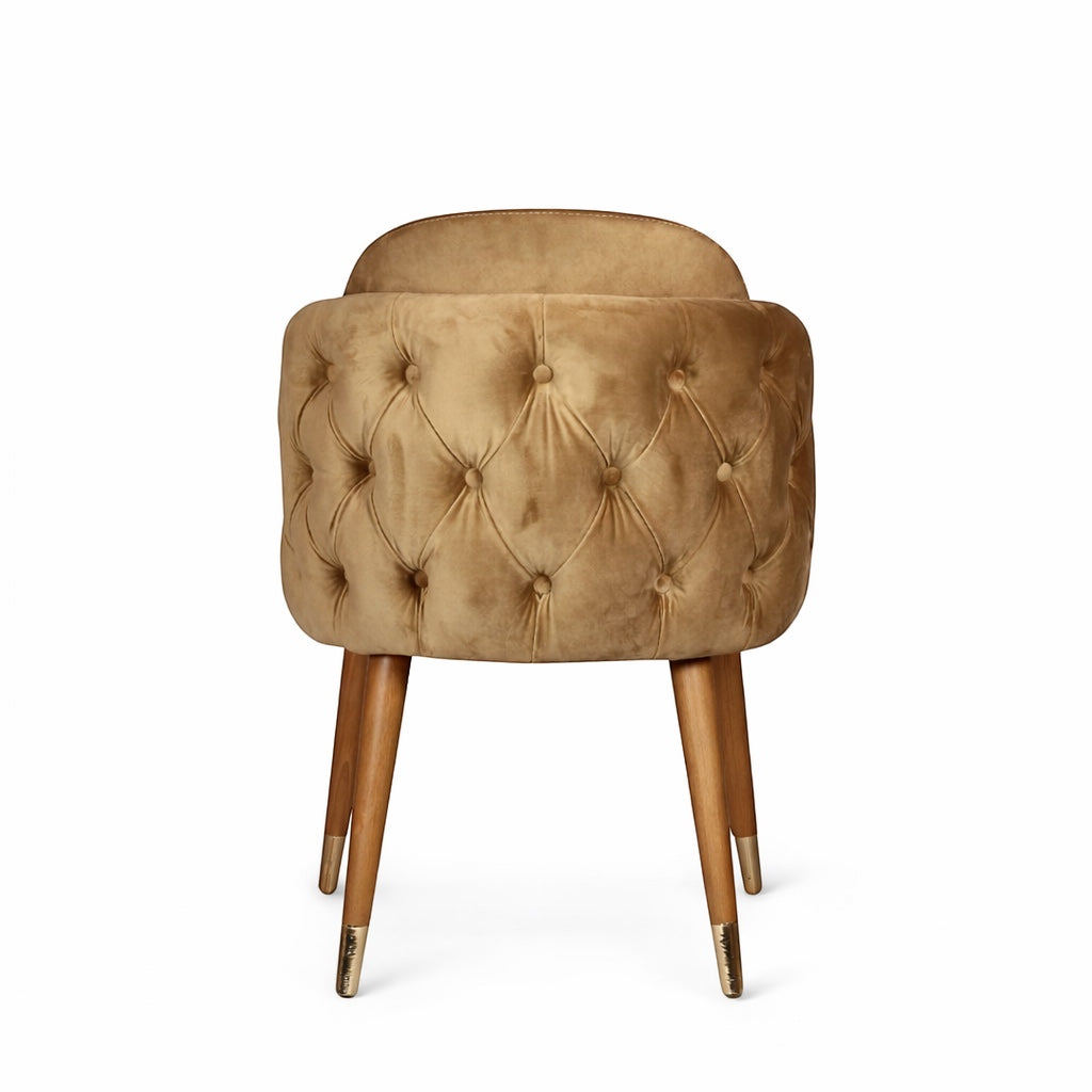 Back view of the Vaya Home Sorelle dining chair showing beige velvet upholstery, button-tufted back detail, and tapered wood legs.