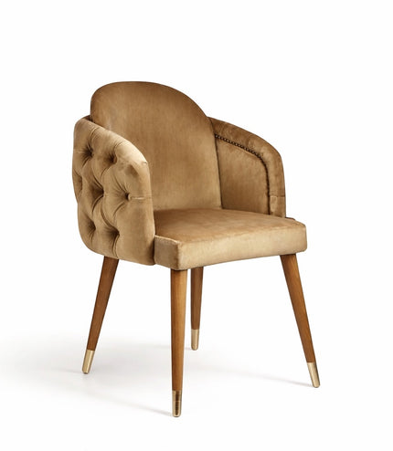 Vaya Home Sorelle dining chair with beige velvet upholstery, tufted back detail, curved arms, and gold leg caps.
