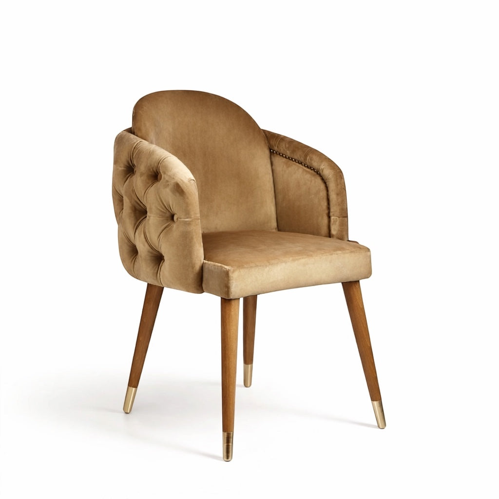 Vaya Home Sorelle dining chair with beige velvet upholstery, tufted back detail, curved arms, and gold leg caps.