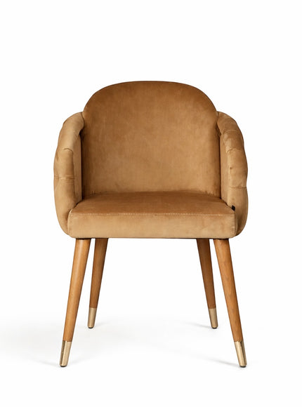 Front view of the Vaya Home Sorelle dining chair featuring beige velvet upholstery, curved arms, and tapered wood legs with gold caps.
