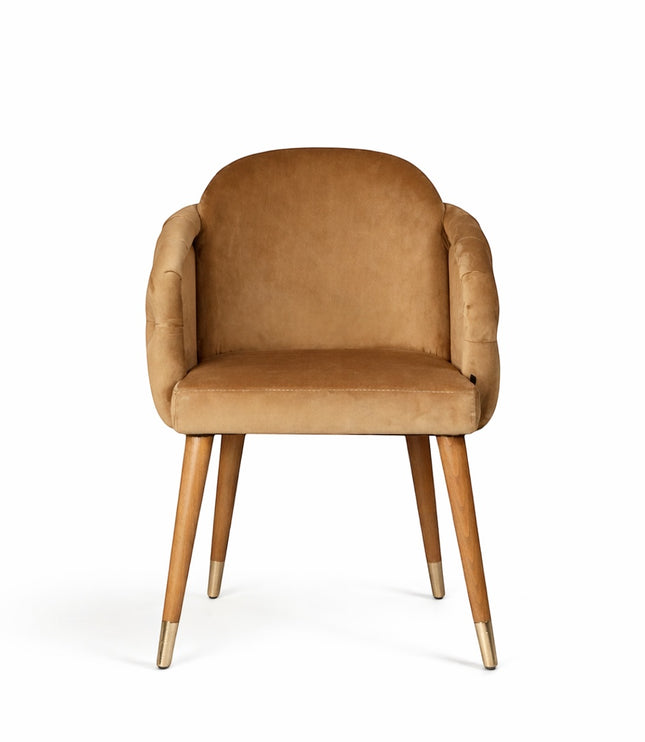 Front view of the Vaya Home Sorelle dining chair featuring beige velvet upholstery, curved arms, and tapered wood legs with gold caps.