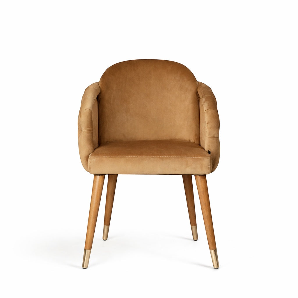 Front view of the Vaya Home Sorelle dining chair featuring beige velvet upholstery, curved arms, and tapered wood legs with gold caps.