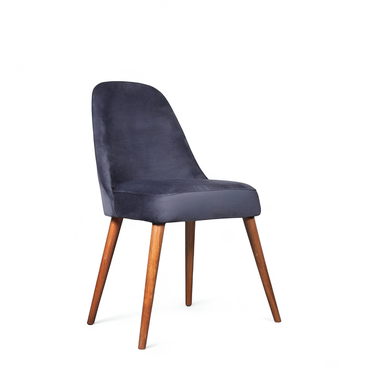Front angled view of the Vaya Home Stretto dining chair with dark blue velvet upholstery and tapered wood legs.