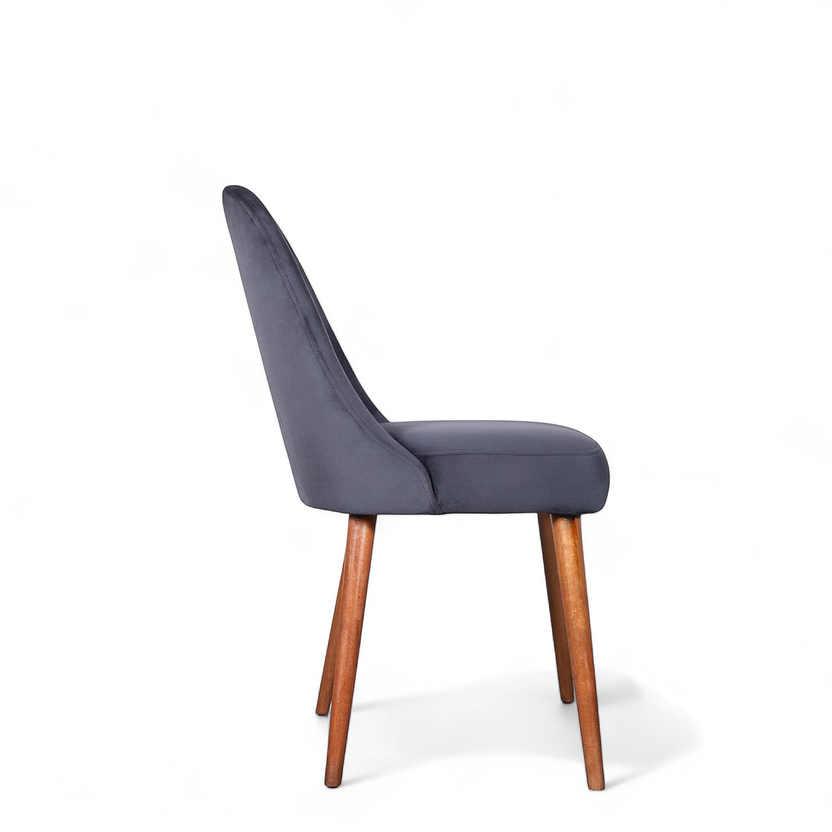 Side view of the Vaya Home Stretto dining chair with dark blue velvet upholstery and tapered wood legs.