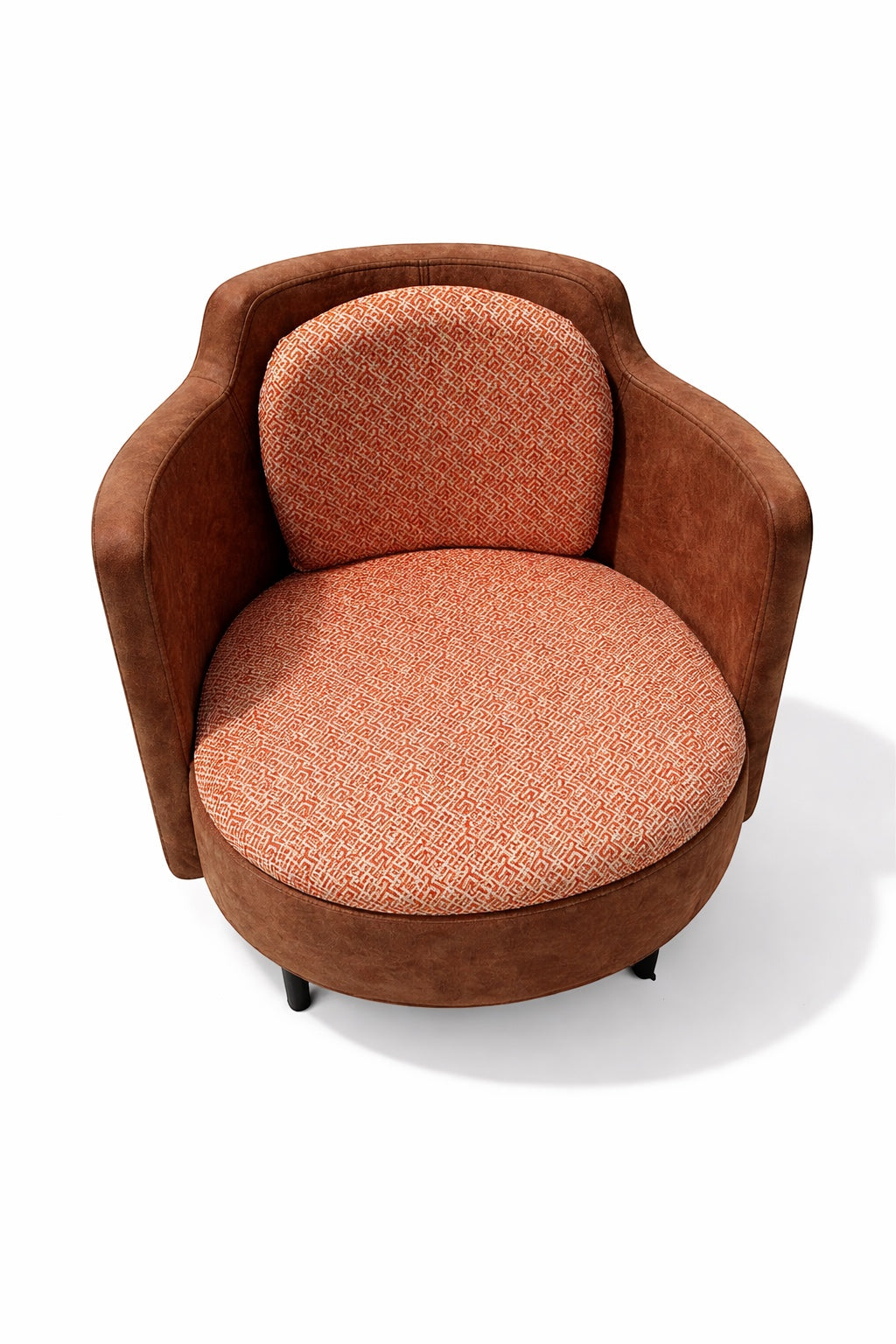 Vaya Home Terracotta armchair with rounded silhouette, brown eco-leather exterior, and orange geometric patterned upholstery on seat and back.