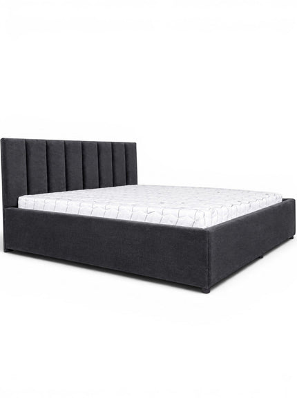 Front angled view of the Vaya Home Torino bed with dark gray upholstery, a channel-tufted headboard, and a low platform frame.