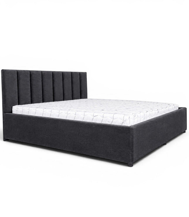 Front angled view of the Vaya Home Torino bed with dark gray upholstery, a channel-tufted headboard, and a low platform frame.