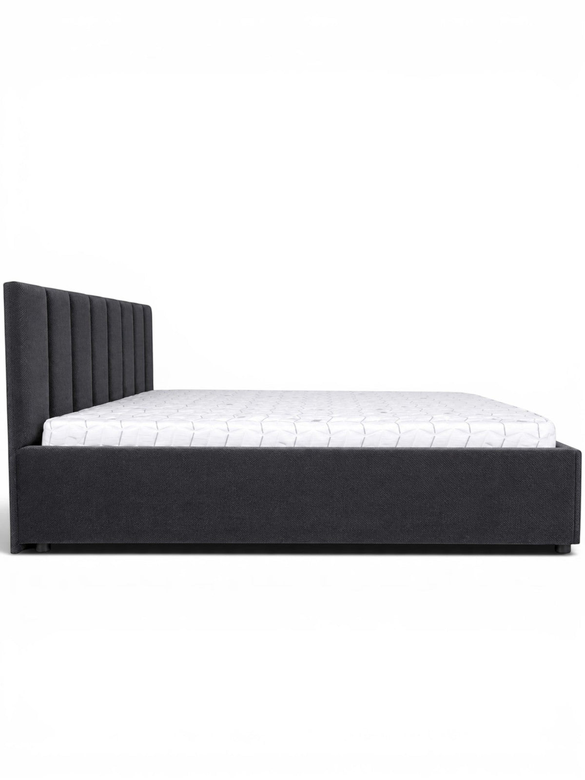 Side view of the Vaya Home Torino bed featuring dark gray upholstery, a channel-tufted headboard, and a low platform frame.