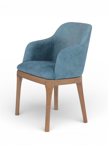 Front angled view of the Vaya Home Verve dining chair with blue upholstery, curved arms, and tapered wood legs.